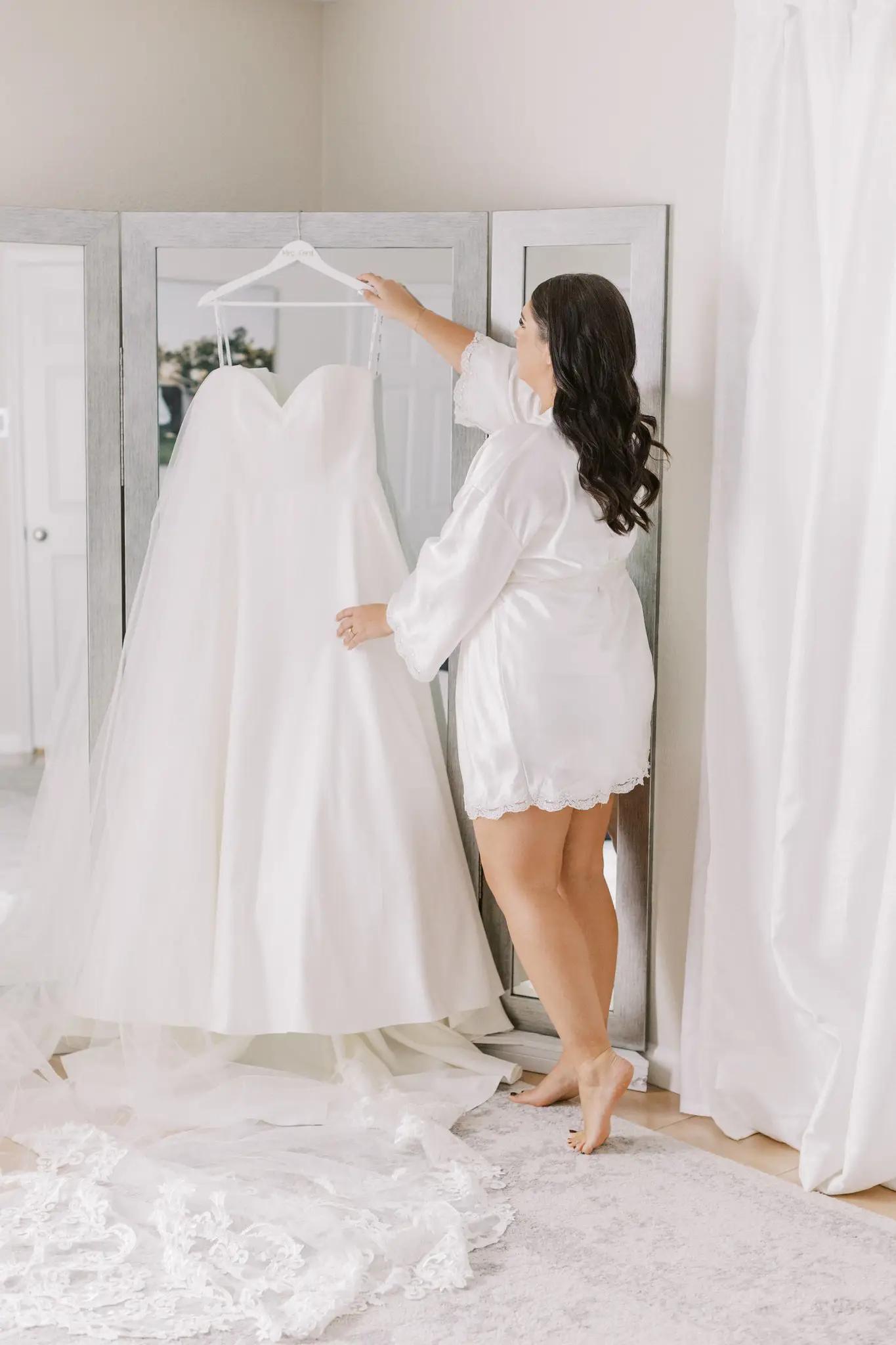 Bride hanging wedding dress